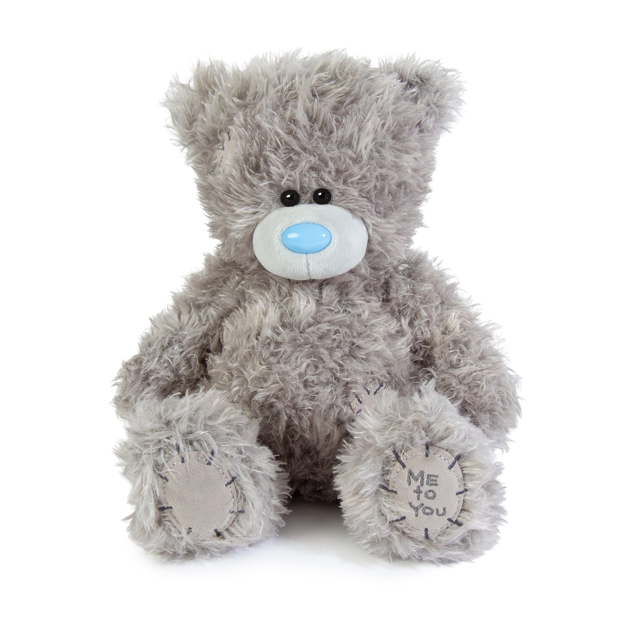 Gray teddy bear with a blue nose on a white background