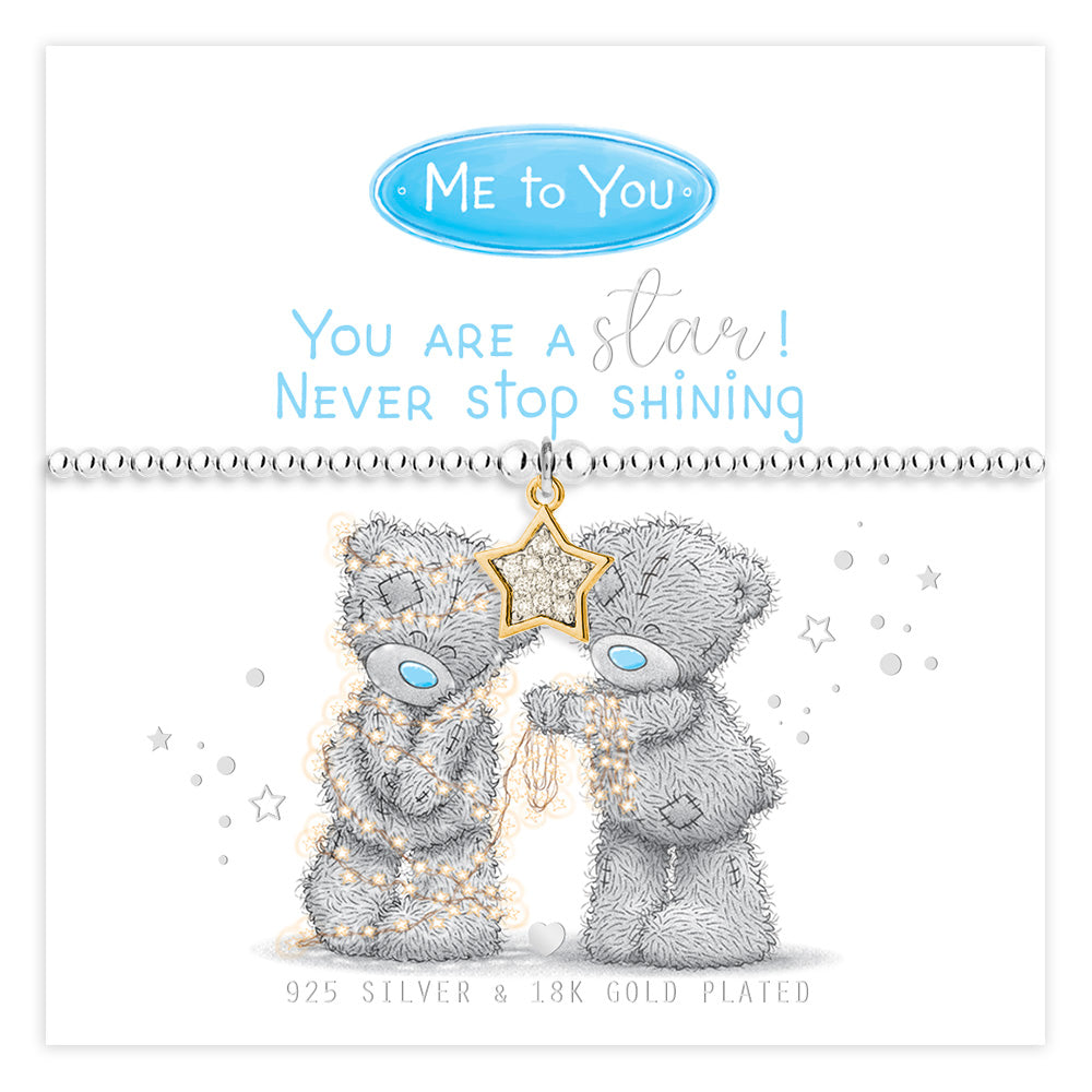 A Me to You branded silver bracelet with a gold-plated star charm, displayed on its white retail backing card. The card features a message reading 'You are a star! Never stop shining' and shows the gray Me to You bear design adorned with gold stars.