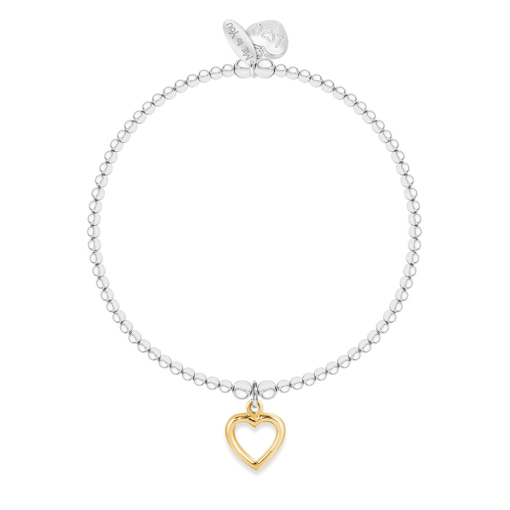A delicate silver beaded bracelet with a small gold heart-shaped charm, displayed on a clean white background.