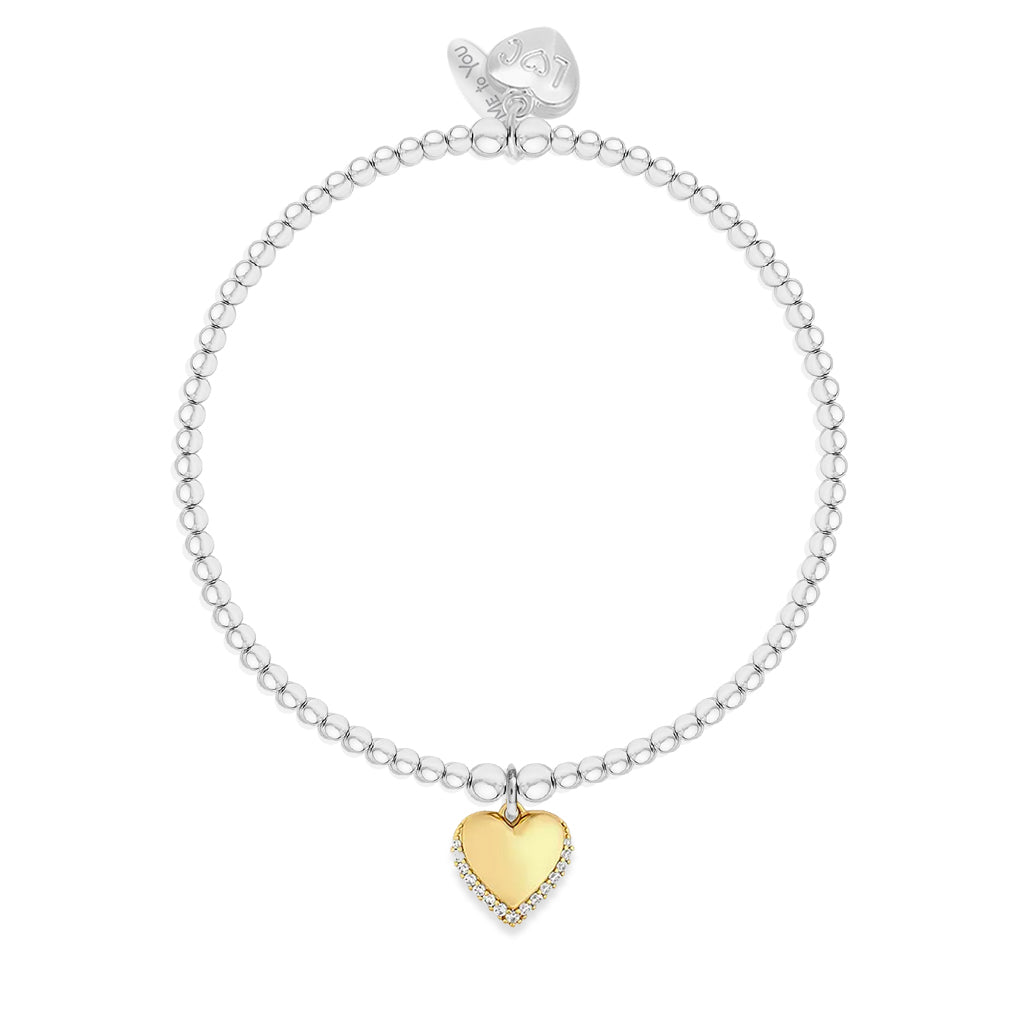 A silver beaded bracelet with a small gold heart charm outlined with clear stones, displayed on a clean white background.