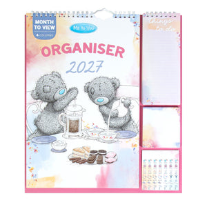 A Me To You 2027 spiral-bound monthly planner organizer with a pink cover featuring two teddy bears at a tea table, plus three pink page inserts on the right side.
