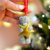 Resin Tatty Teddy Christmas decoration holding gold star wth red ribbon in lifestyle setting